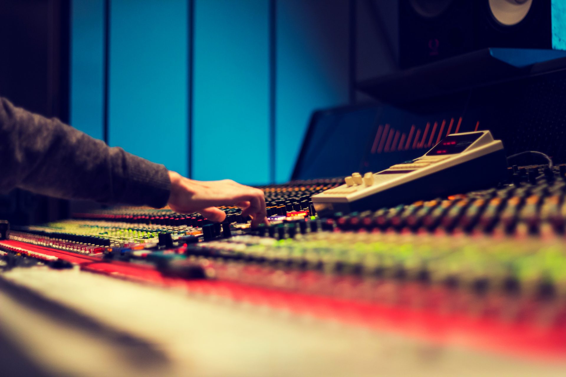 closeup photography of man operating audio mixer